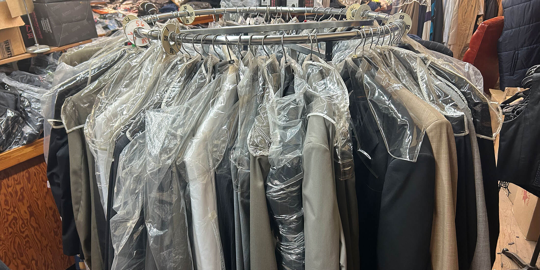 A round rack of suits and dress jackets in extended sizes inside Kornfeld's Department Store.
